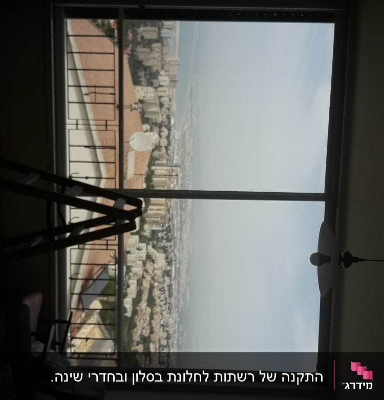 חלון עם מסגרת אלומיניום ונוף עירוני